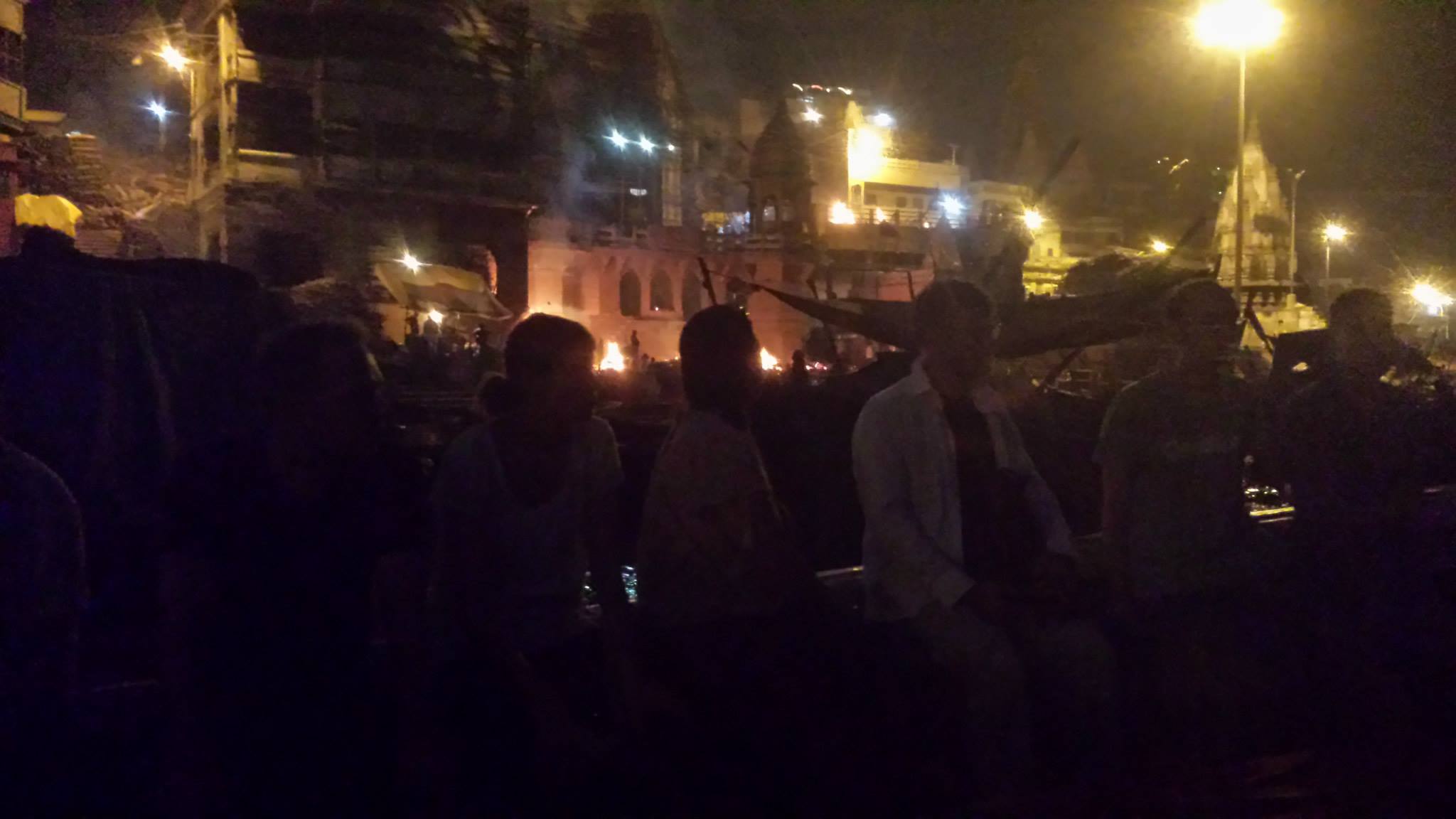 The ghats at sunset — smoke from Manikarnika visible against the sky